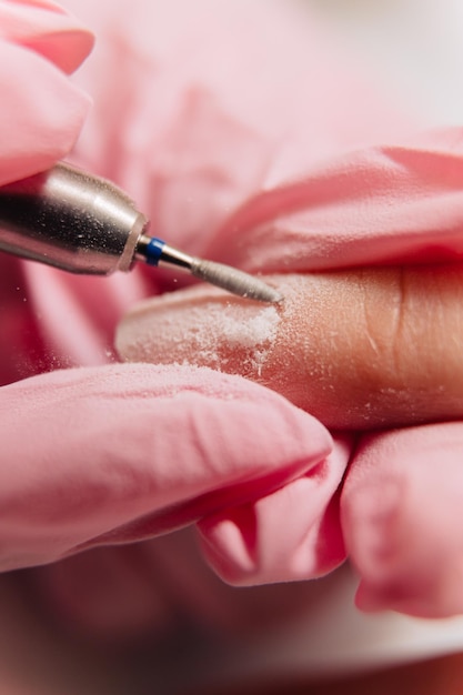 Proceso de manicura El maestro pule la uña usando una máquina automatizada Quitaesmalte de taladro