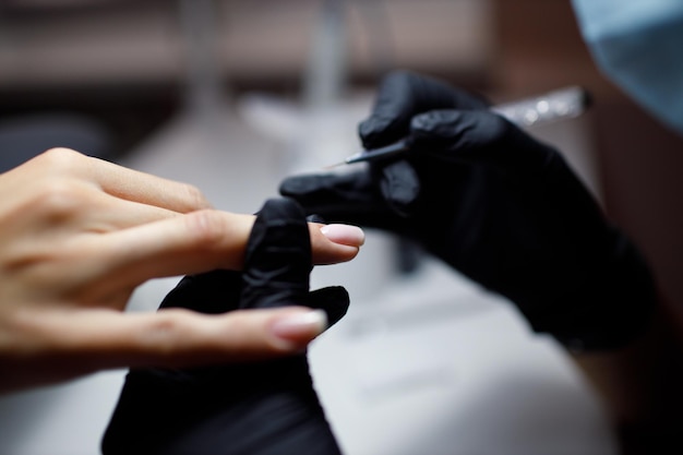 Proceso de manicura manos femeninas esmalte de uñas.