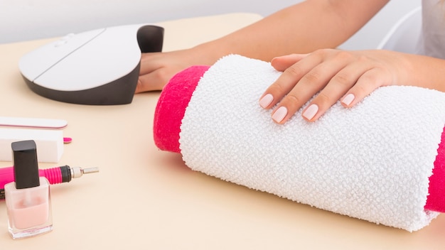 Foto proceso de manicura de vista lateral en el salón.