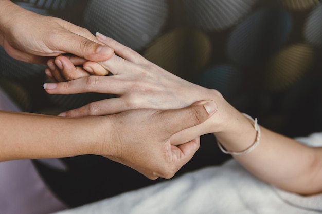 Proceso de masaje de manos Estiramiento del tendón de los nudillos de la muñeca y acupresión para relajación y curación en el spa para la atención médica de mujeres asiáticas