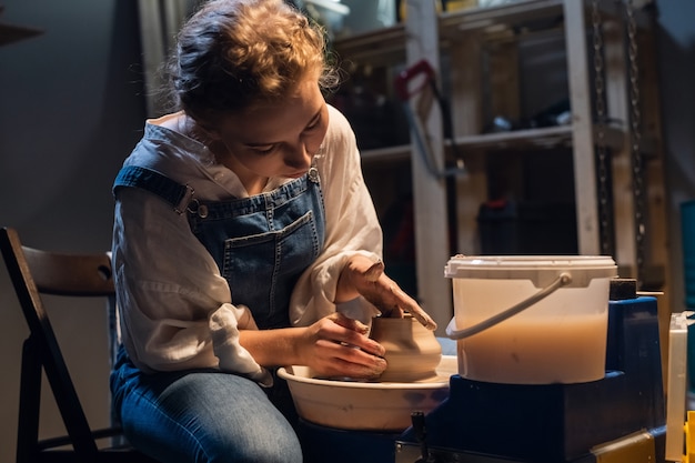 El proceso de modelado de una vasija de barro muestra a un joven alfarero en su taller.