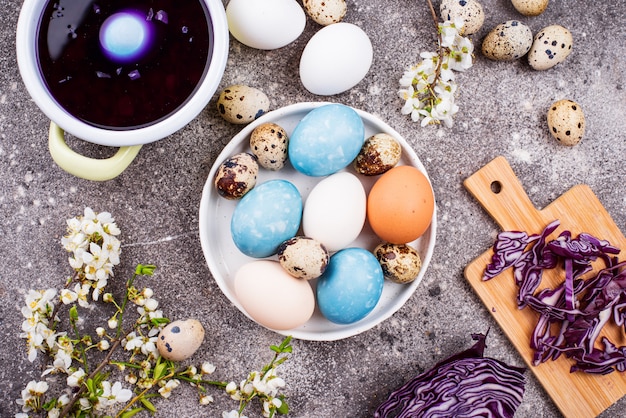 Proceso de pintar huevos de pascua en azul