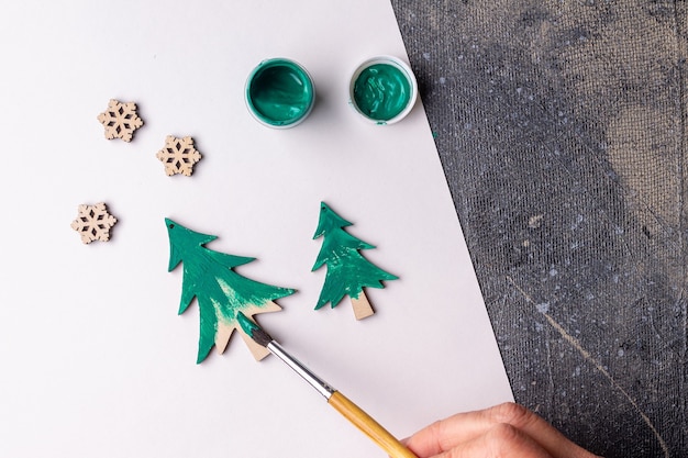 Foto el proceso de pintar juguetes de madera para el árbol de navidad.