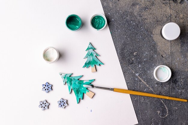 El proceso de pintar juguetes de madera para el árbol de Navidad.