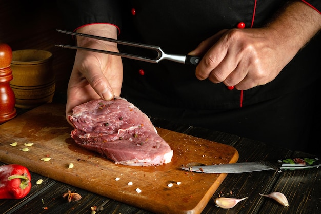 El proceso de preparación de un filete de carne por las manos de un chef en una mesa de la cocina con especias aromáticas Cocinar jugosos y sabrosos shish kebab para el almuerzo