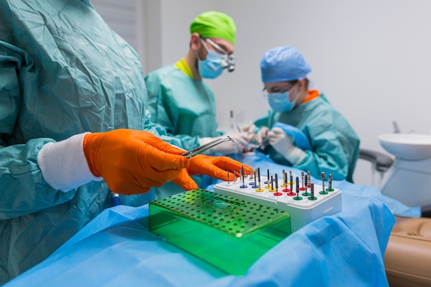 Proceso de primer plano del cirujano dentista profesional masculino realizando la operación Instalar el implante dental