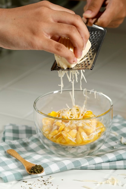 Proceso de queso rallado sobre maíz con mantequilla Paso a paso Hacer bocadillos en la cocina