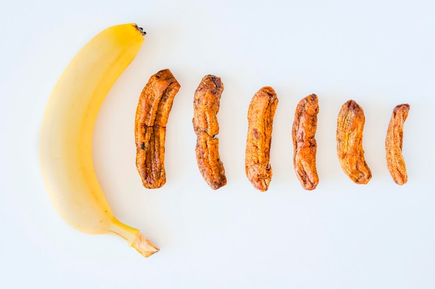 Proceso de secado de banano Diferentes tamaños de banano seco Plátanos secos sobre un fondo concreto