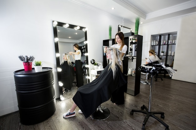 Foto proceso de teñido de cabello en salón de belleza.