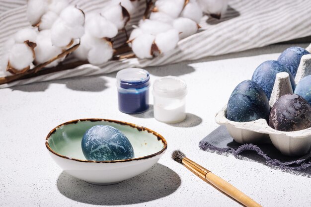 El proceso de teñir los huevos de Pascua con pinturas acrílicas azules y blancas.