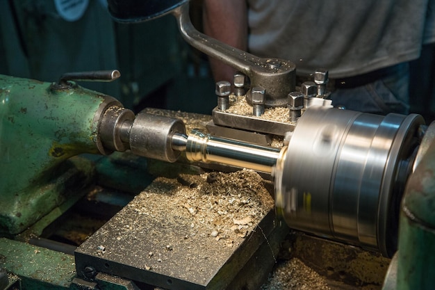 Foto processamento manual do torno na fábrica da indústria metalúrgica