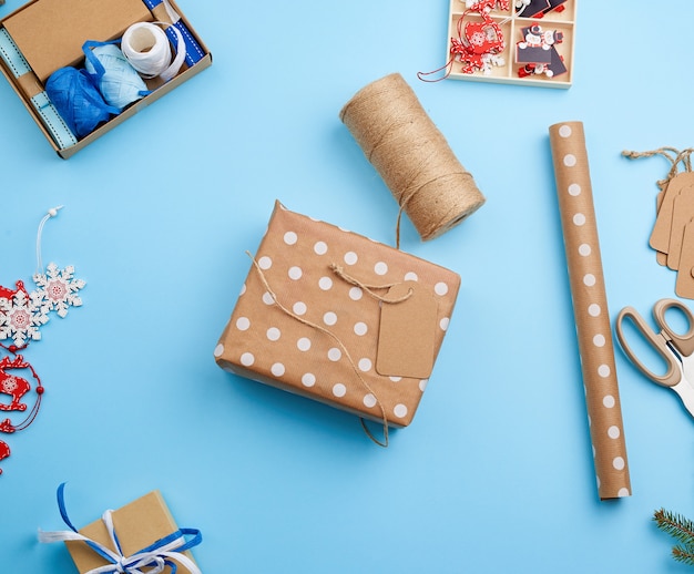 Foto processo de embalagem e embalagem de caixas em papel pardo festivo, ao lado da decoração da caixa de bagagem