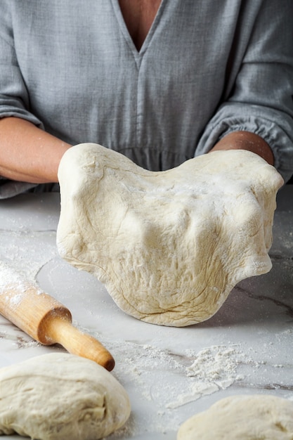 Processo de fazer pizza, mão de mulher trabalhando com massa e farinha