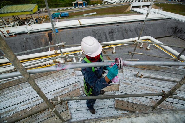 Processo de inspeção de trabalhadores masculinos cor vermelha solda de solda limpando desenvolvedor branco no com tanques de aço de gasoduto de carbono