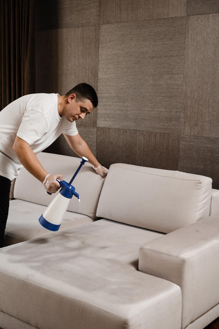 Processo de limpeza a seco para remover manchas e sujeira do sofá em casa Serviço de limpeza profissional Pulverização de detergente no sofá para limpeza a seco usando máquina extratora