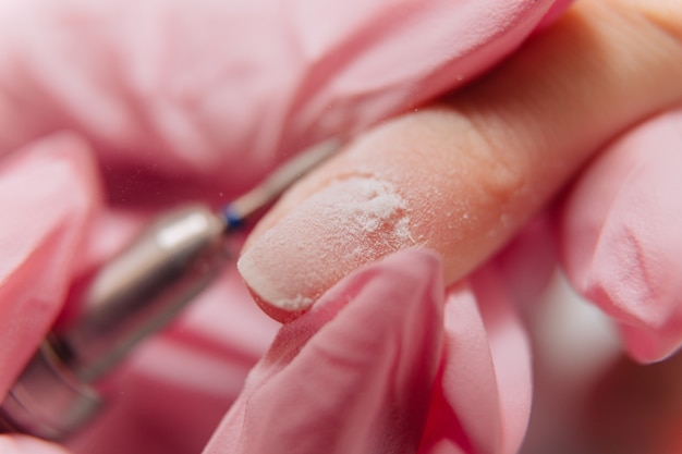 Foto processo de manicure. o mestre lustra a unha usando uma máquina automatizada. removedor de polimento de broca.