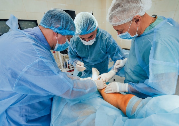 Foto processo de operação da cirurgia de trauma. grupo de cirurgiões na sala de cirurgia com equipamento cirúrgico.