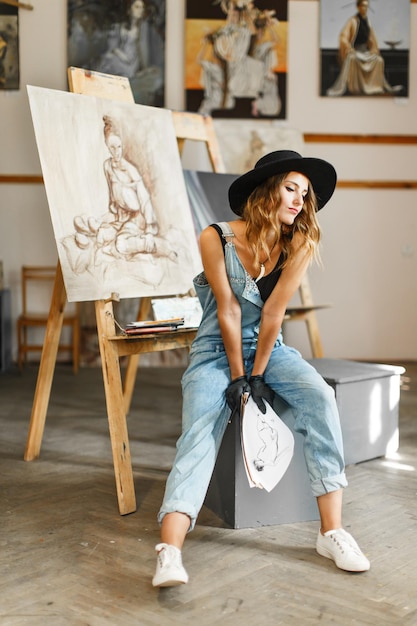 Processo de pose de garota do artista no estúdio