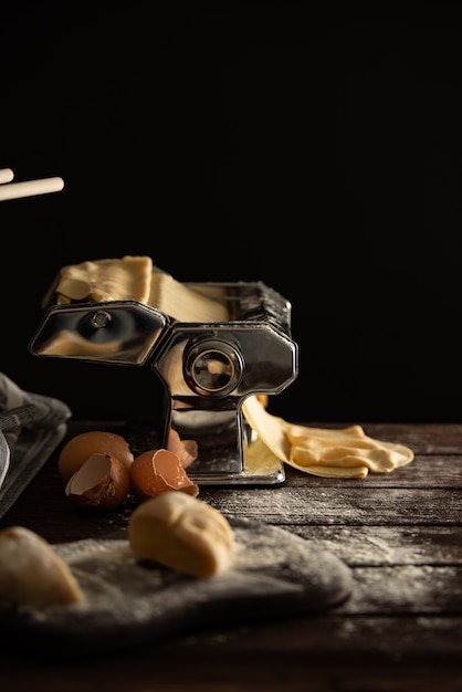 Processo de preparação de massa caseira para massas em uma máquina de macarrão, cozinha italiana tradicional