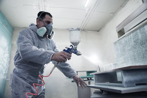 Foto processo de produção e fabricação de móveis de madeira na fábrica trabalhador de macacão pinta madeira com spray de tinta