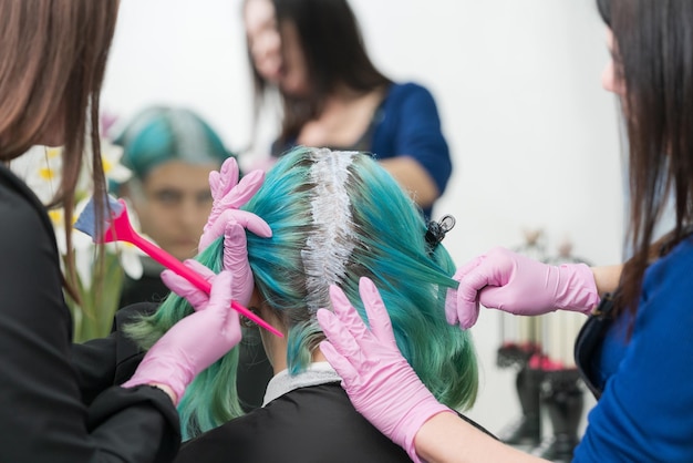 Processo de tintura de cabelo no salão de beleza Cabeleireiros aplicando tinta ao cabelo durante o branqueamento das raízes do cabelo