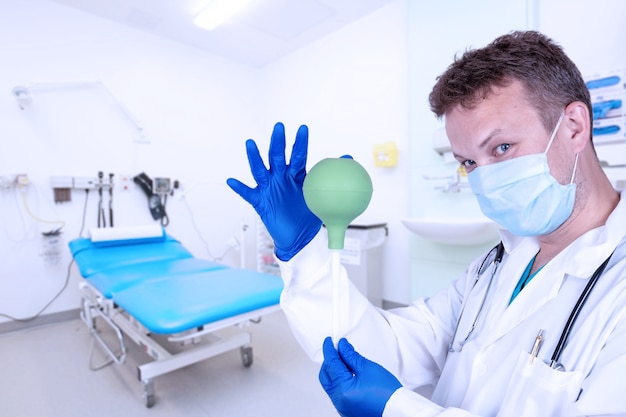 Foto un proctólogo en una sala de procedimientos con ducha, un enema es un dispositivo con una punta suave y dura para lavar los intestinos.