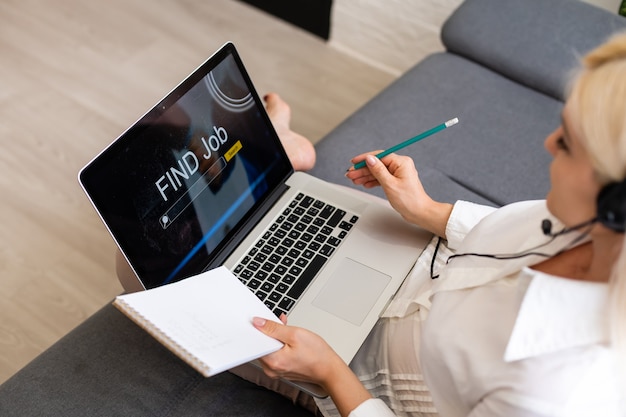 Procura de emprego online Mãos com computador lendo anúncios de emprego