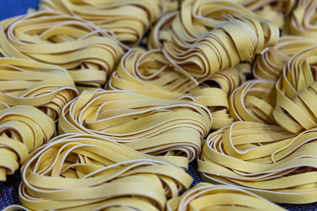 Produção artesanal de macarrão em um restaurante italiano Macarrão amarelo em processo de secagem