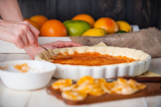 Produção de bolo com marmelada cítrica e fatias de tangerina