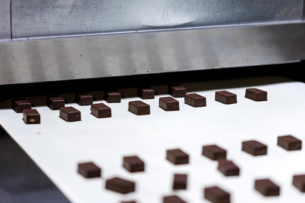 Produção de doces de chocolate na correia transportadora na fábrica