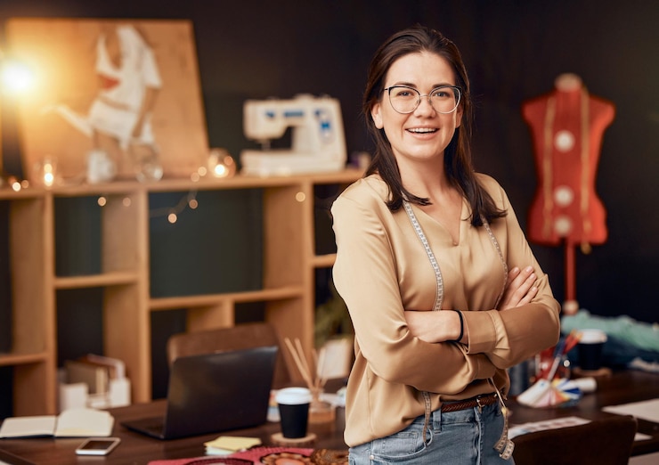 Foto produção de moda e retrato de designer em oficina com liderança de sucesso e startup de roupas boutique criativa de design de moda e mulher com fita métrica para tecidos e roupas têxteis