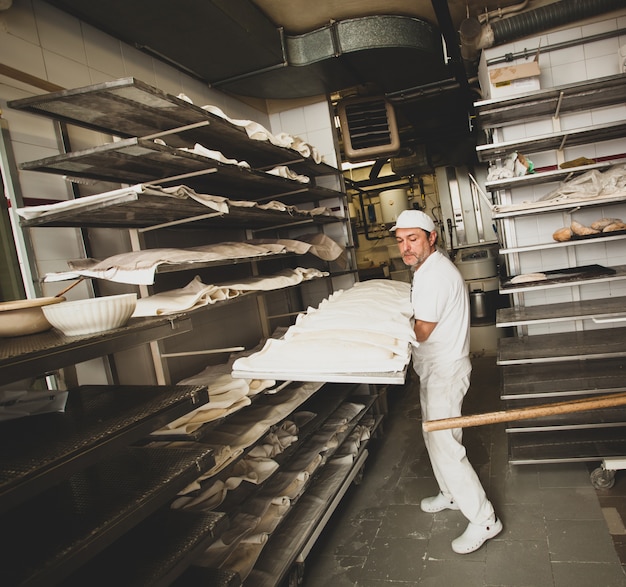 Produção de pão assado com forno de lenha em uma padaria.