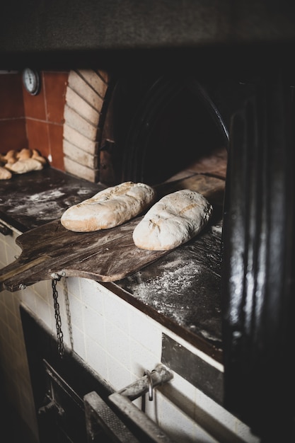 Foto produção de pão assado com forno de lenha em uma padaria.