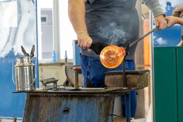 Producción manual de vidrio por soplado de vidrio por trabajador en la fábrica.