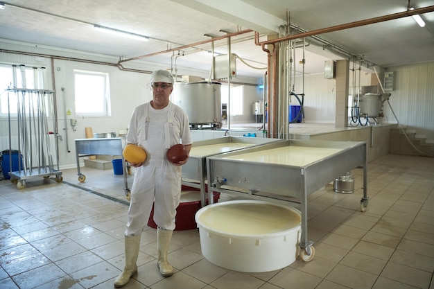 Producción de queso empleado quesero masculino que trabaja en la fábrica