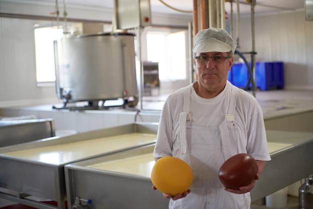 Producción de queso empleado quesero masculino que trabaja en la fábrica