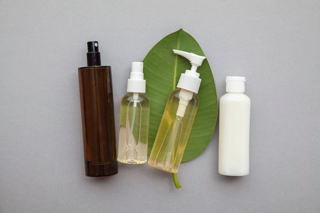 Producto cosmético natural orgánico con una hoja verde sobre un fondo gris