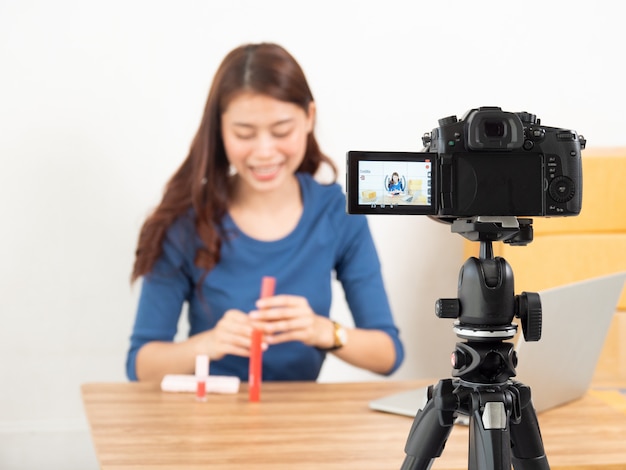 Producto de revisión de mujer asiática en vivo con cámara digital en línea