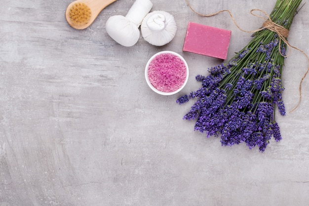 Productos de aseo y ramo de lavanda fresca sobre fondo de mesa de madera blanca