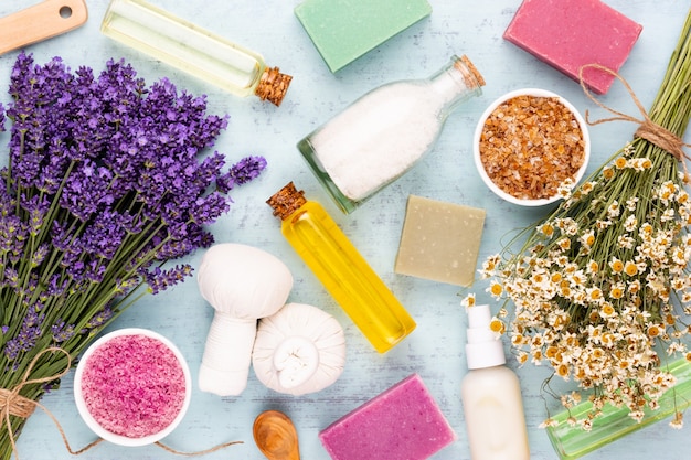 Productos de aseo y ramo de lavanda fresca sobre mesa de madera blanca.