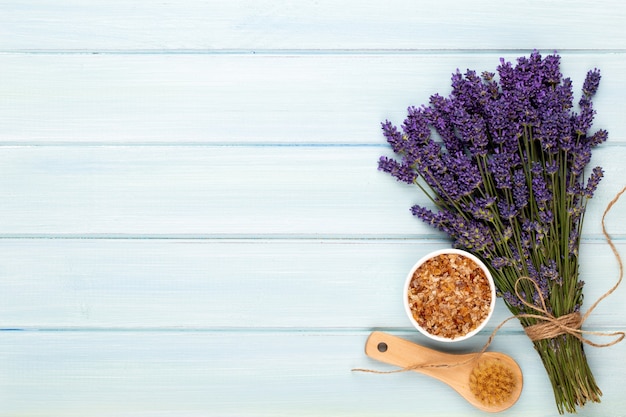 Productos de aseo y ramo de lavanda fresca sobre mesa de madera blanca