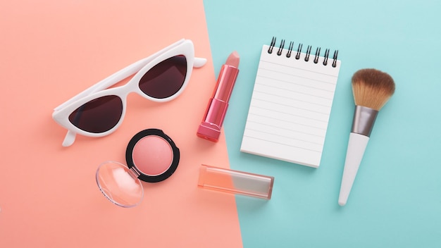Productos de belleza cosmética y gafas de sol con bloc de notas y gafas de sol