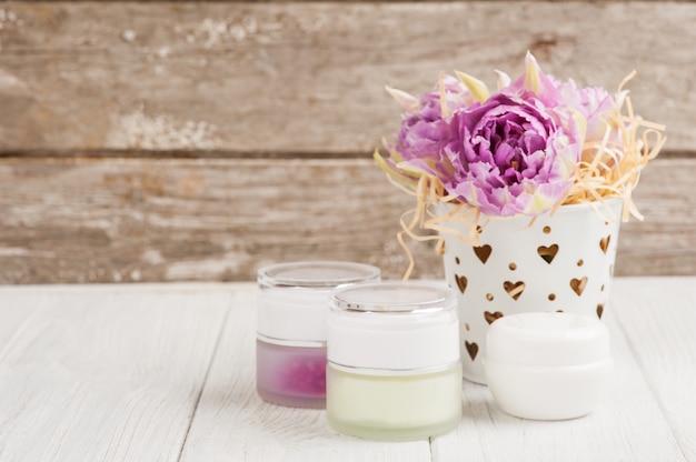 Foto productos de belleza, cosméticos, velas encendidas y tulipanes morados