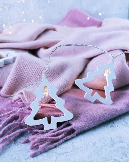 Los productos de cachemira rosa están decorados con linternas navideñas sobre un fondo claro.