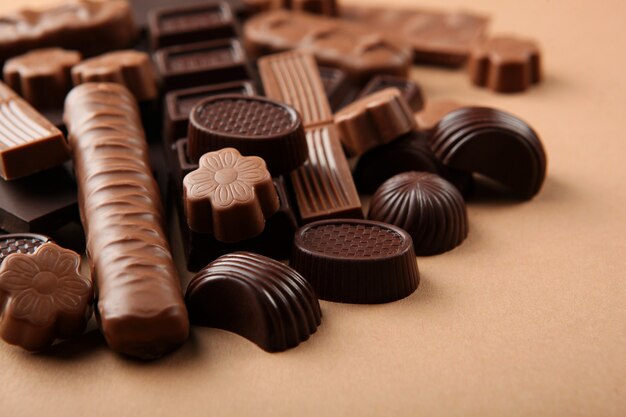 Productos de chocolate de diferentes tipos en un primer plano de la superficie de color con un lugar para el texto