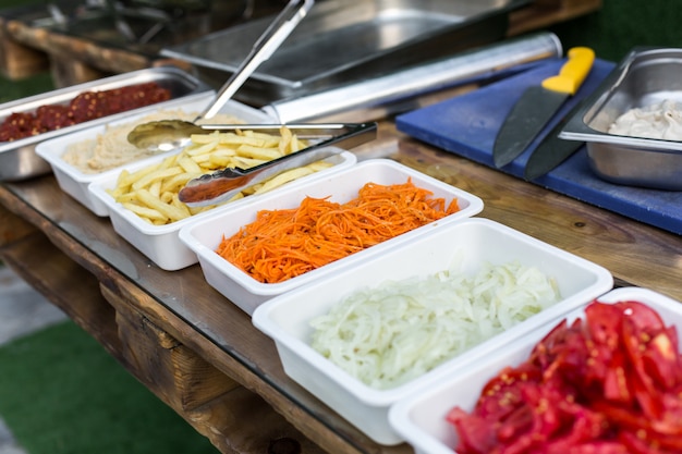 Productos de cocina al aire libre para cocinar falafel en platos sobre una mesa de madera. comida de la calle