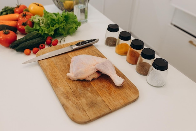 Foto productos para cocinar en la mesa de la cocina verduras frescas diferentes especias pollo