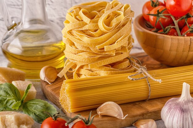 Productos para cocinar: pasta, tomates, ajo, aceite de oliva, albahaca.