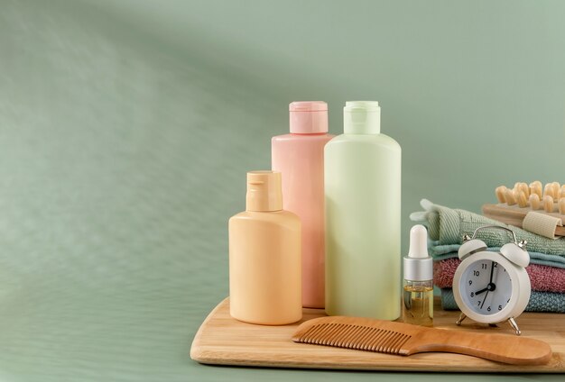 Foto productos cosméticos para el cuidado del cabello y la piel sobre fondo verde. espacio para texto