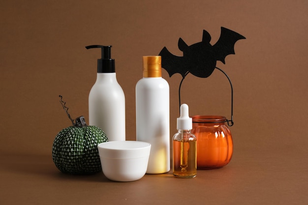 Productos cosméticos y decoración de halloween sobre fondo marrón.